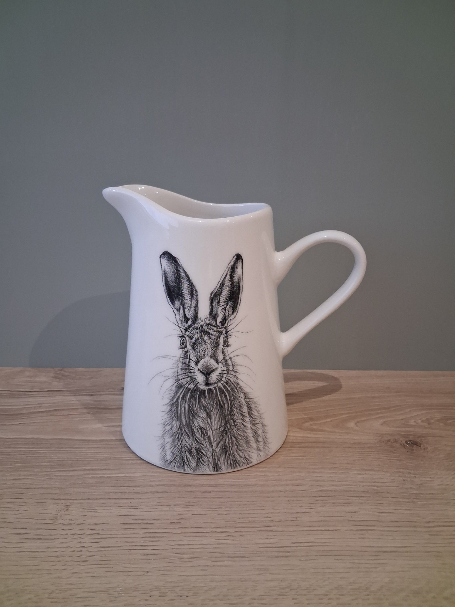 A white ceramic jug featuring a hand drawn image of a hare.