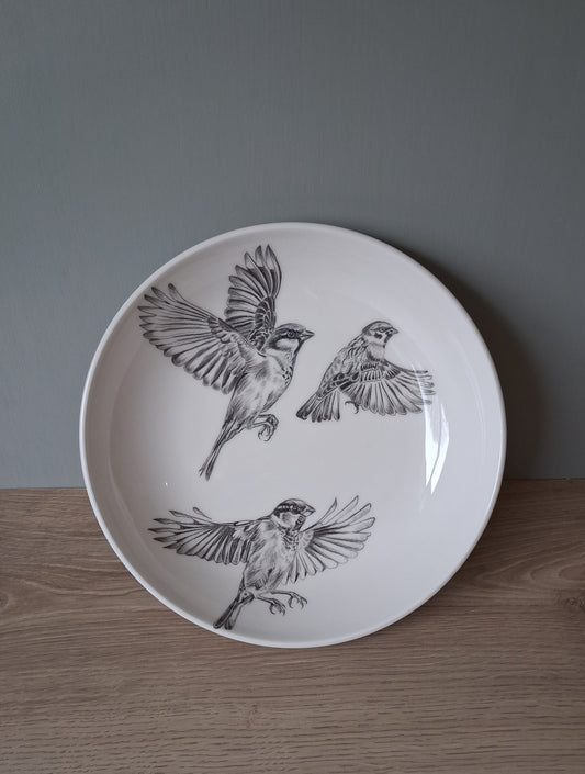 Wite ceramic serving bowl with hand drawn image of 3 sparrows in flight.